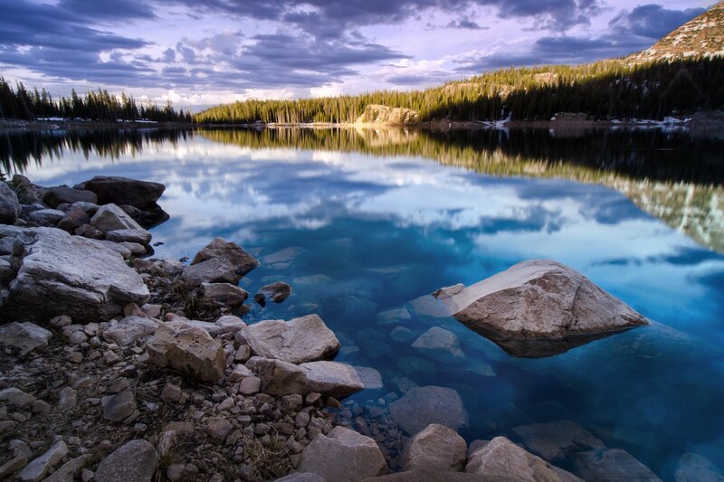 Lake with Rocky Shore — Blue, Serene, Sunset, Photograph, Rocks