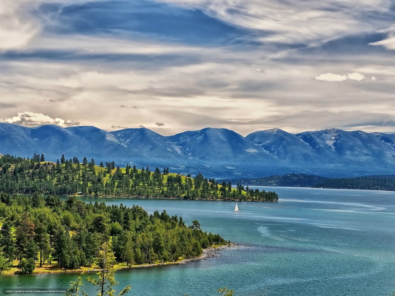 Lake with sailboat and mountains