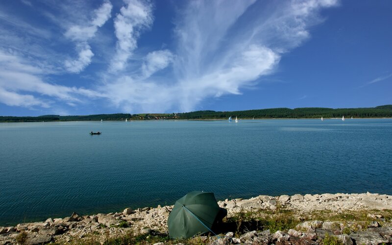 Lake with sailboats and a tent