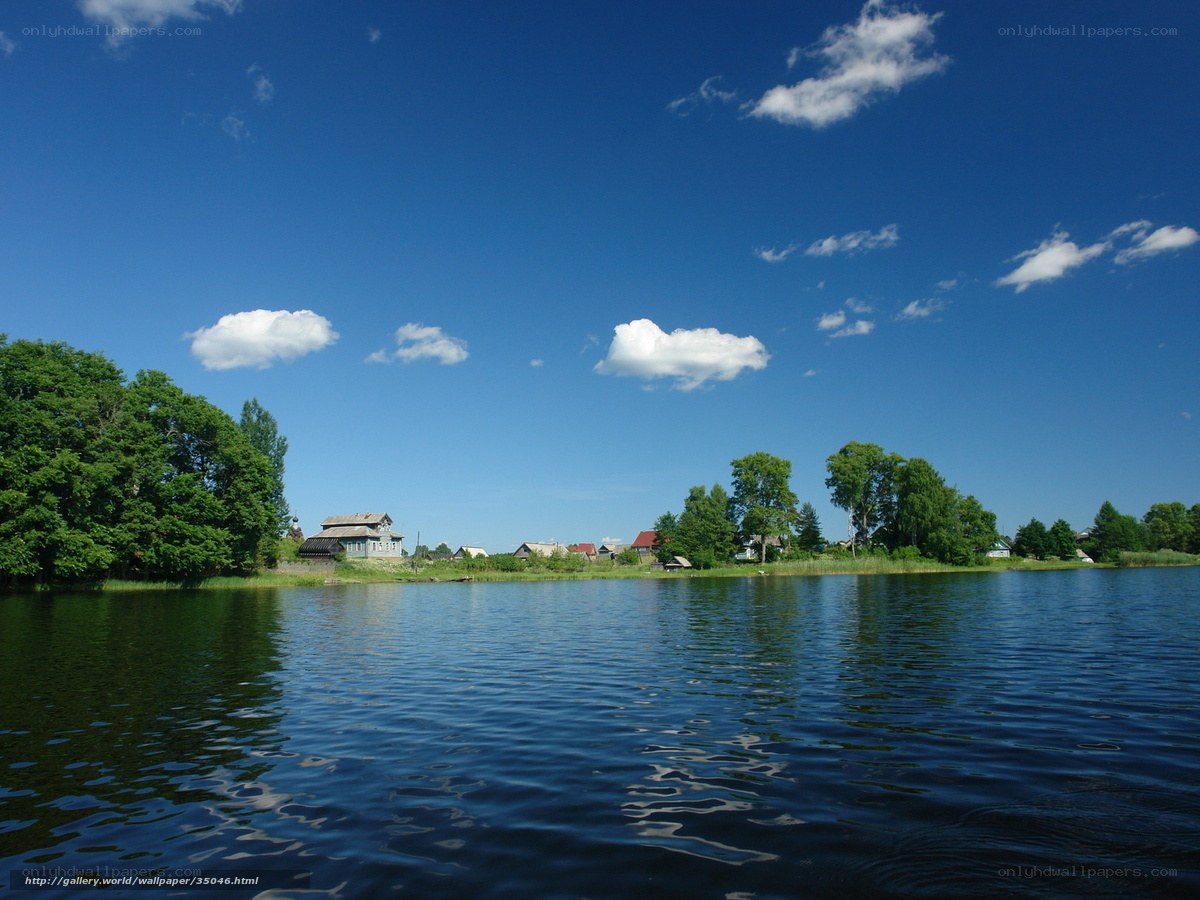 Lake with village under blue sky