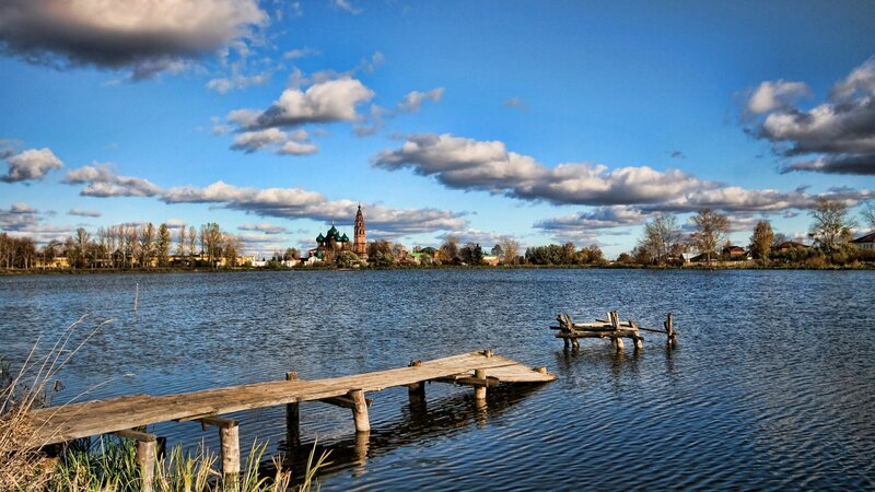 Lake with wooden dock and church