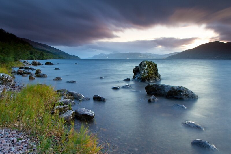 Lakeside at dusk with rocky shore