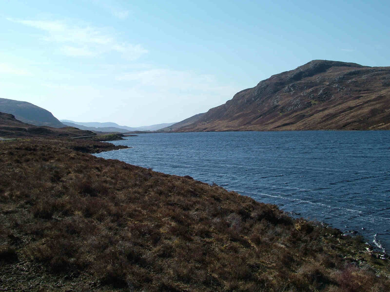 Lakeside hills under blue sky