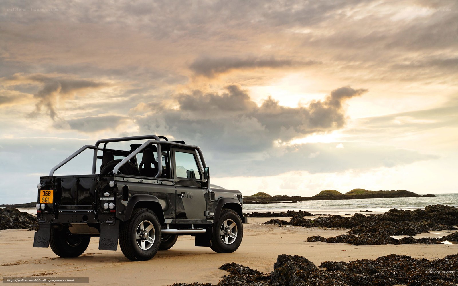 Land Rover on beach at sunset
