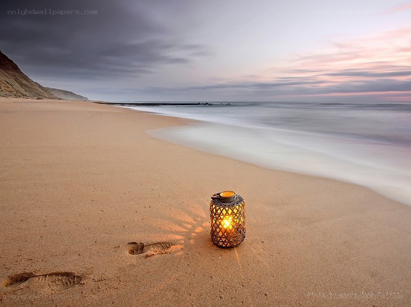 Lantern on a beach at sunset