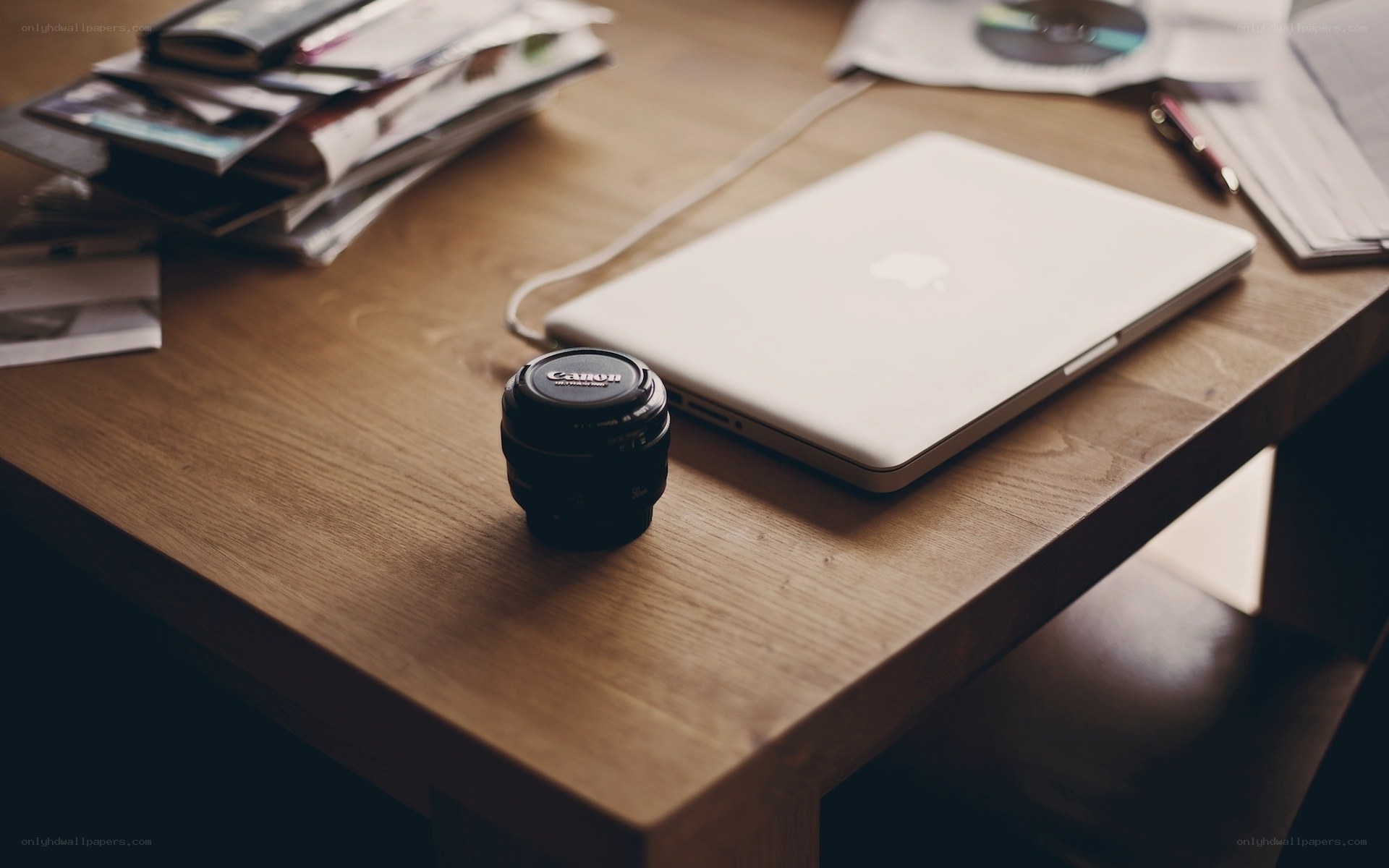 laptop and camera lens on desk