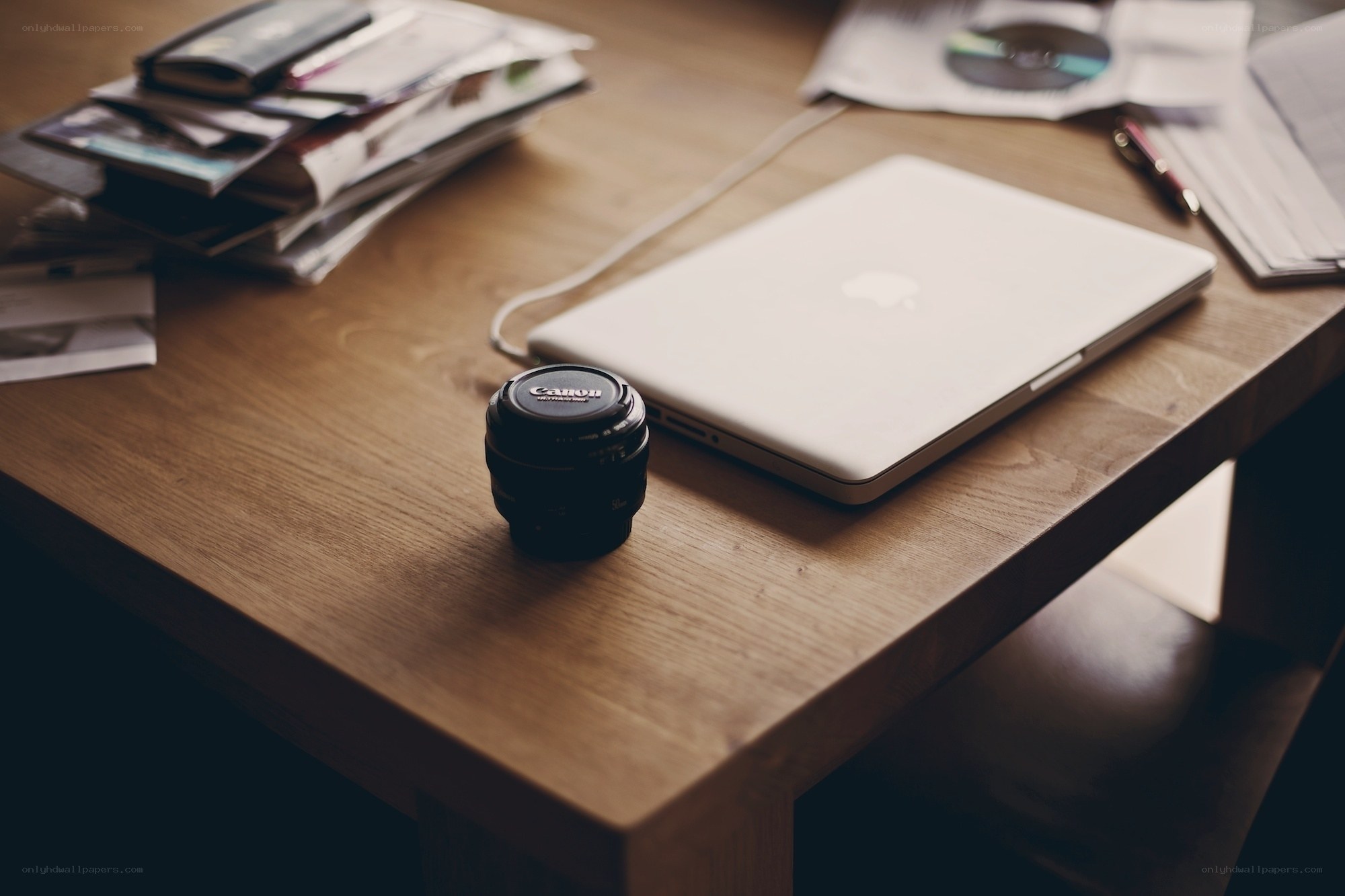 laptop and camera lens on desk