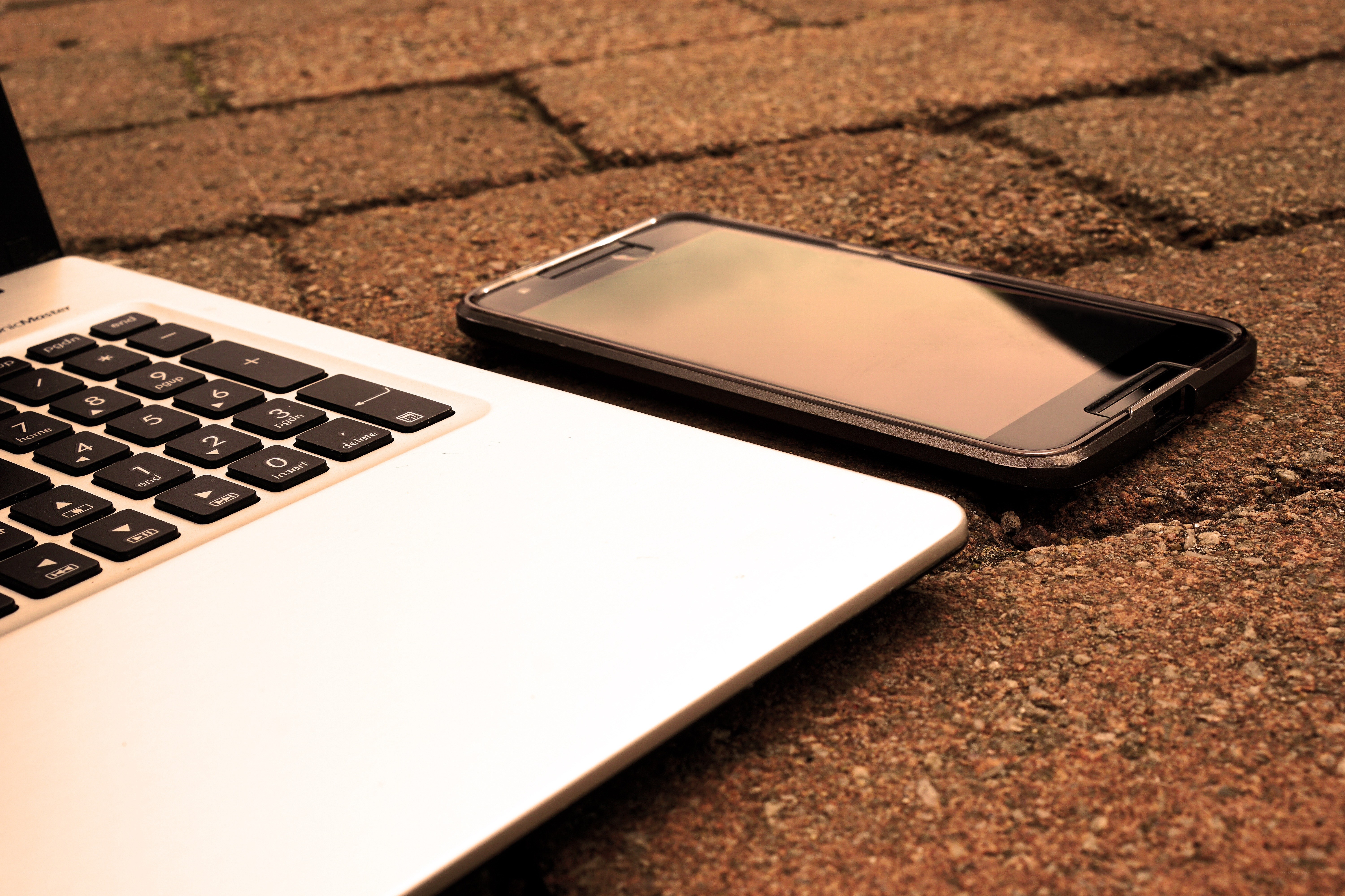 laptop and phone on pavement