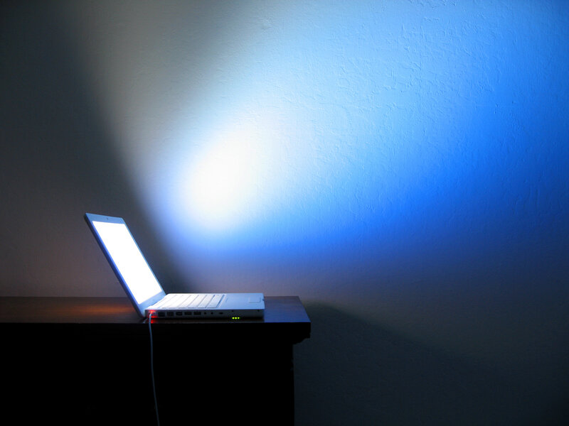 laptop illuminating a wall