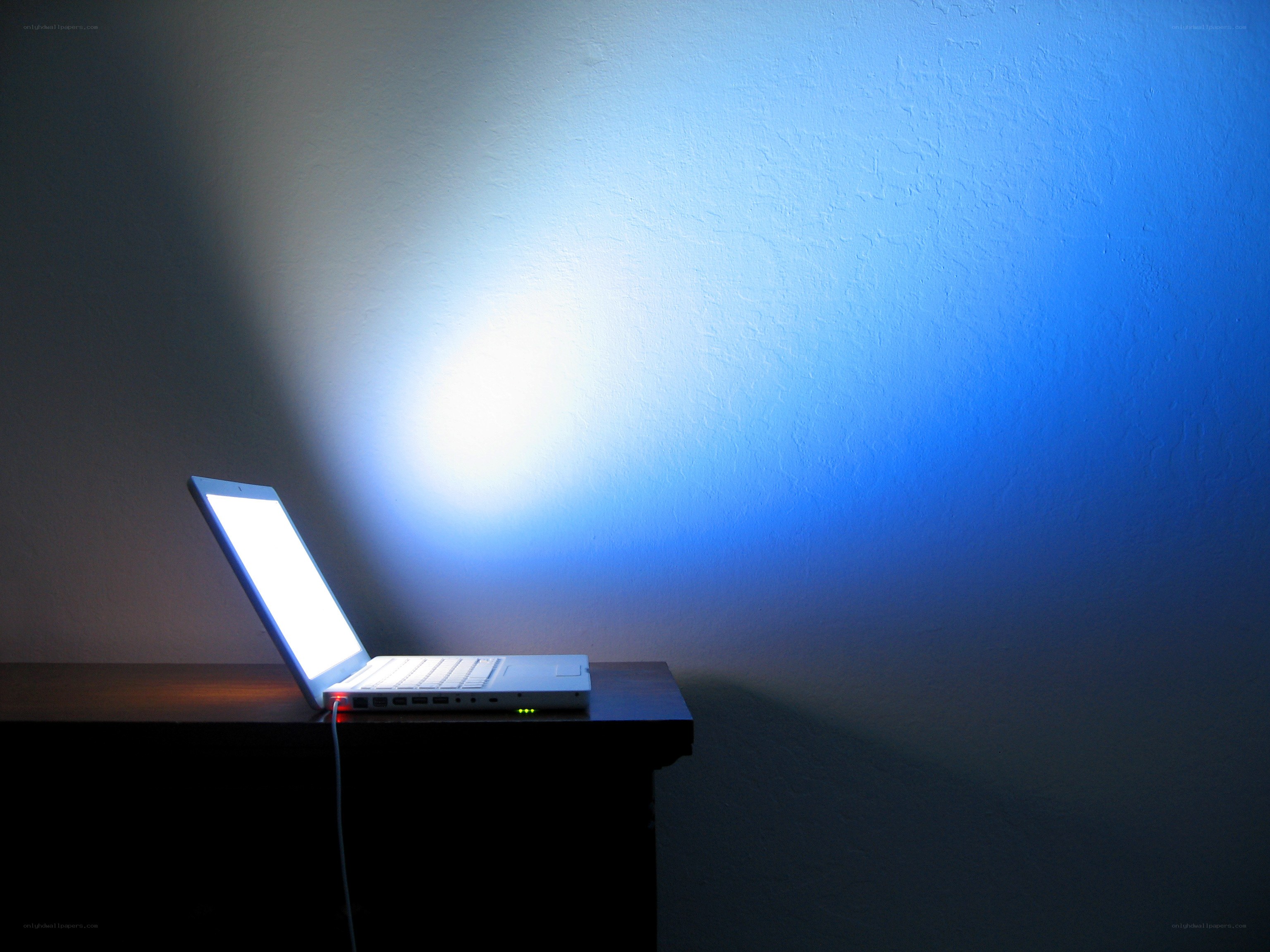 laptop illuminating a wall