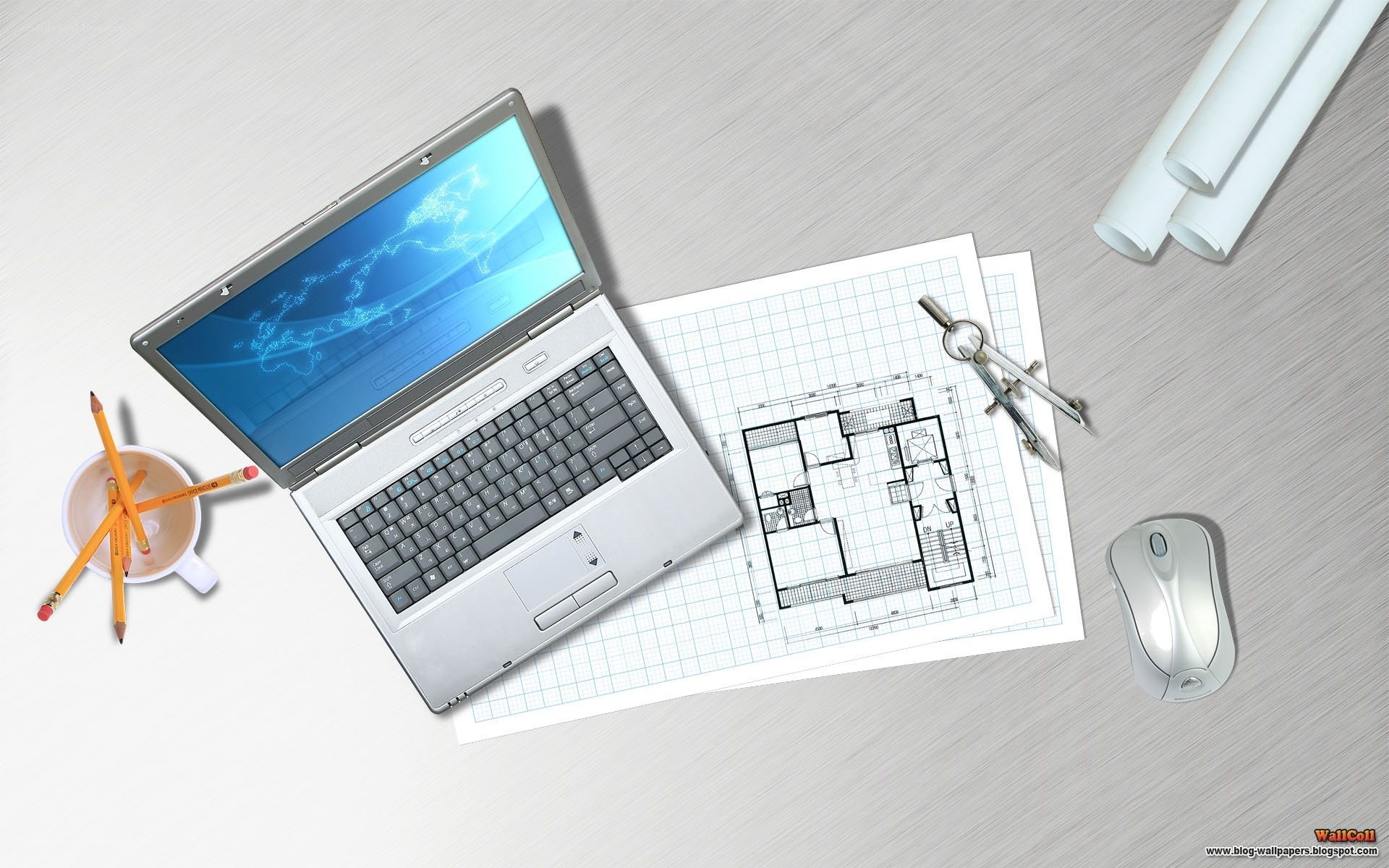 laptop with blueprints on desk