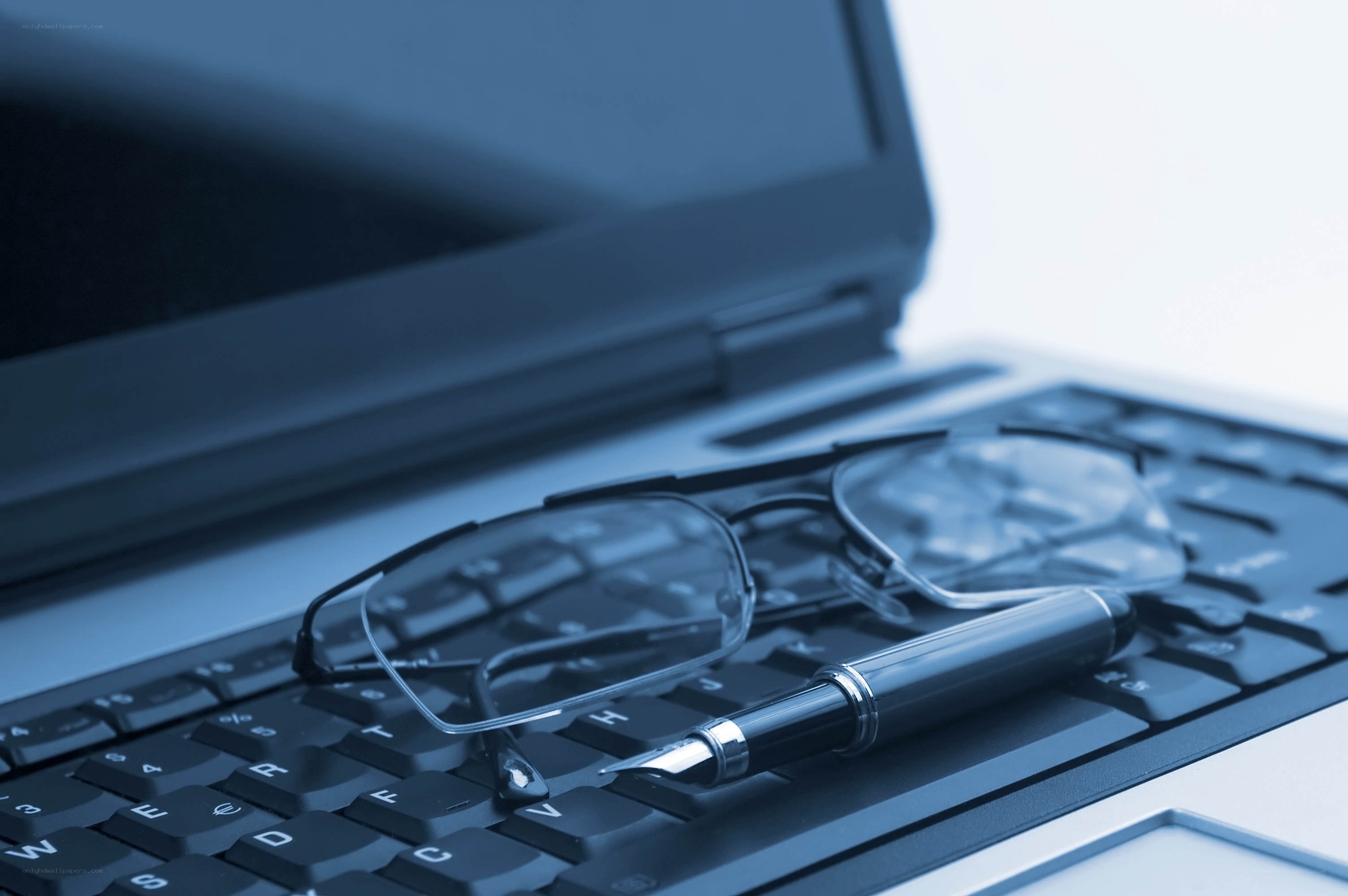 laptop with glasses and pen