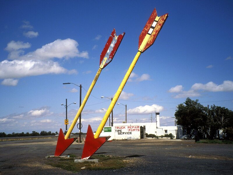 Large arrow sculptures at a repair shop