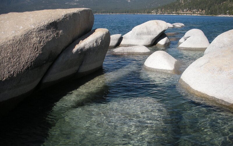 Large boulders in clear lake water