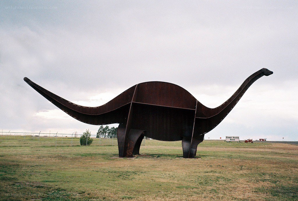 Large dinosaur sculpture in field