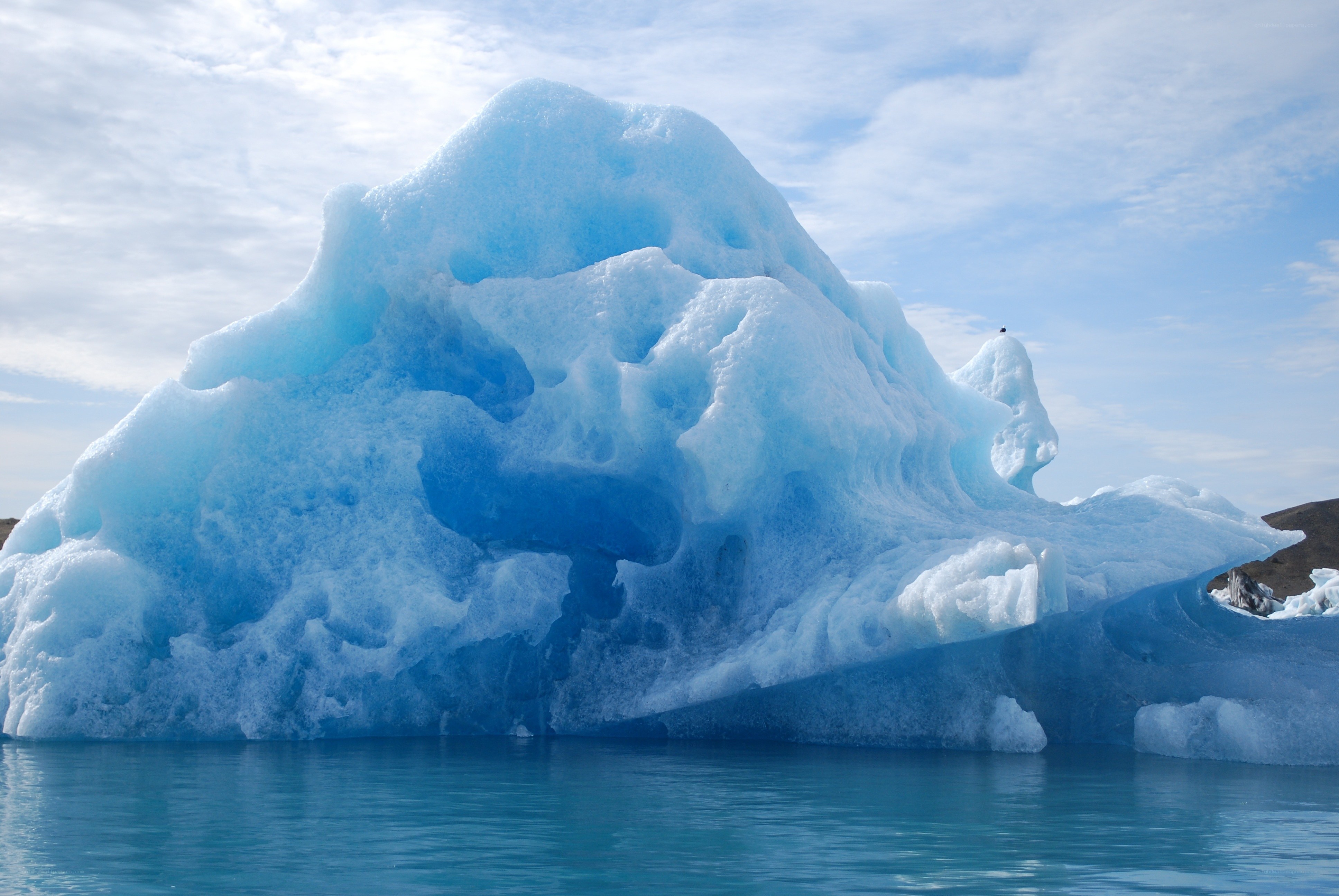 Large iceberg floating in blue water