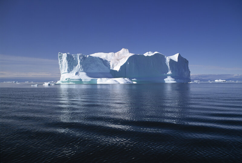 Large iceberg floating in calm sea