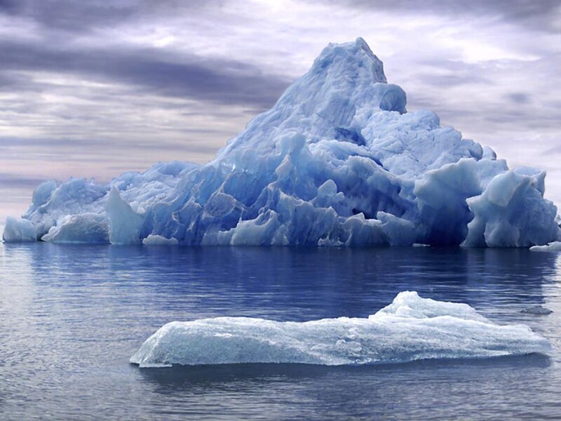 Large iceberg floating in calm water