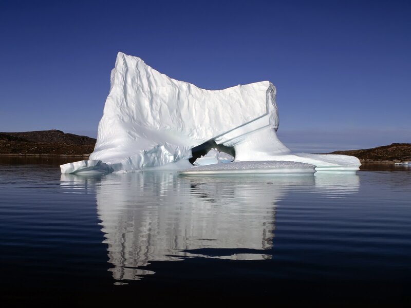 Large iceberg floating in calm water