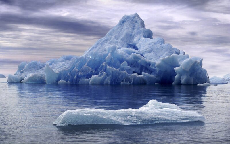Large iceberg floating in calm water