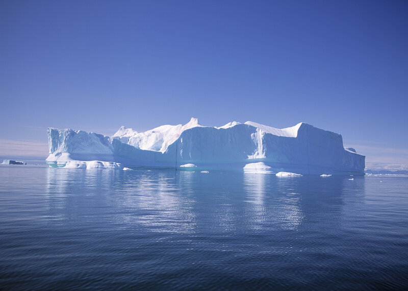 Large iceberg floating in calm water