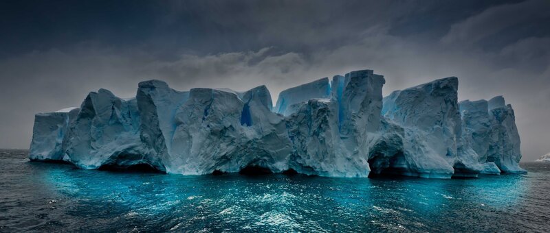 Large Iceberg in Ocean — Blue, Dramatic, Photograph, Clouds, Sky