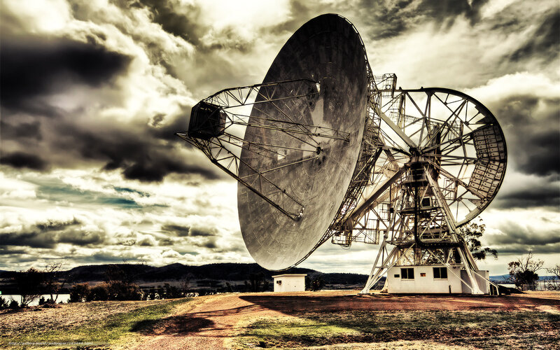 Large satellite dishes under cloudy sky