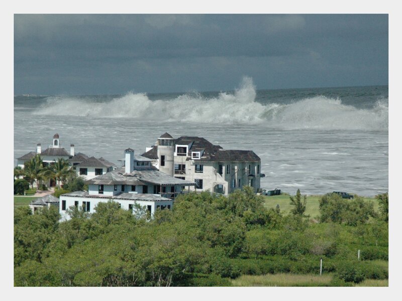 Large waves crashing near coastal homes