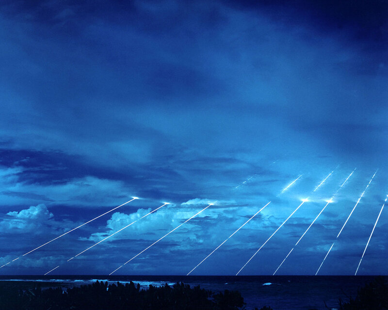 Laser beams over ocean at night
