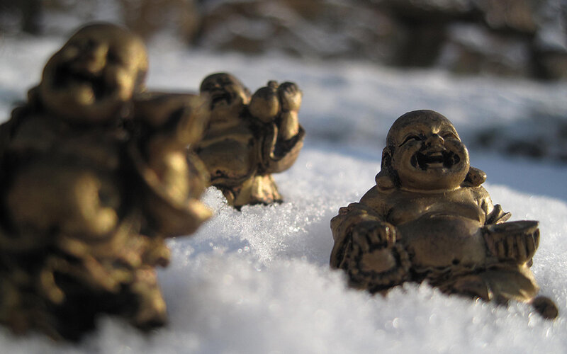 Laughing Buddha statues in snow