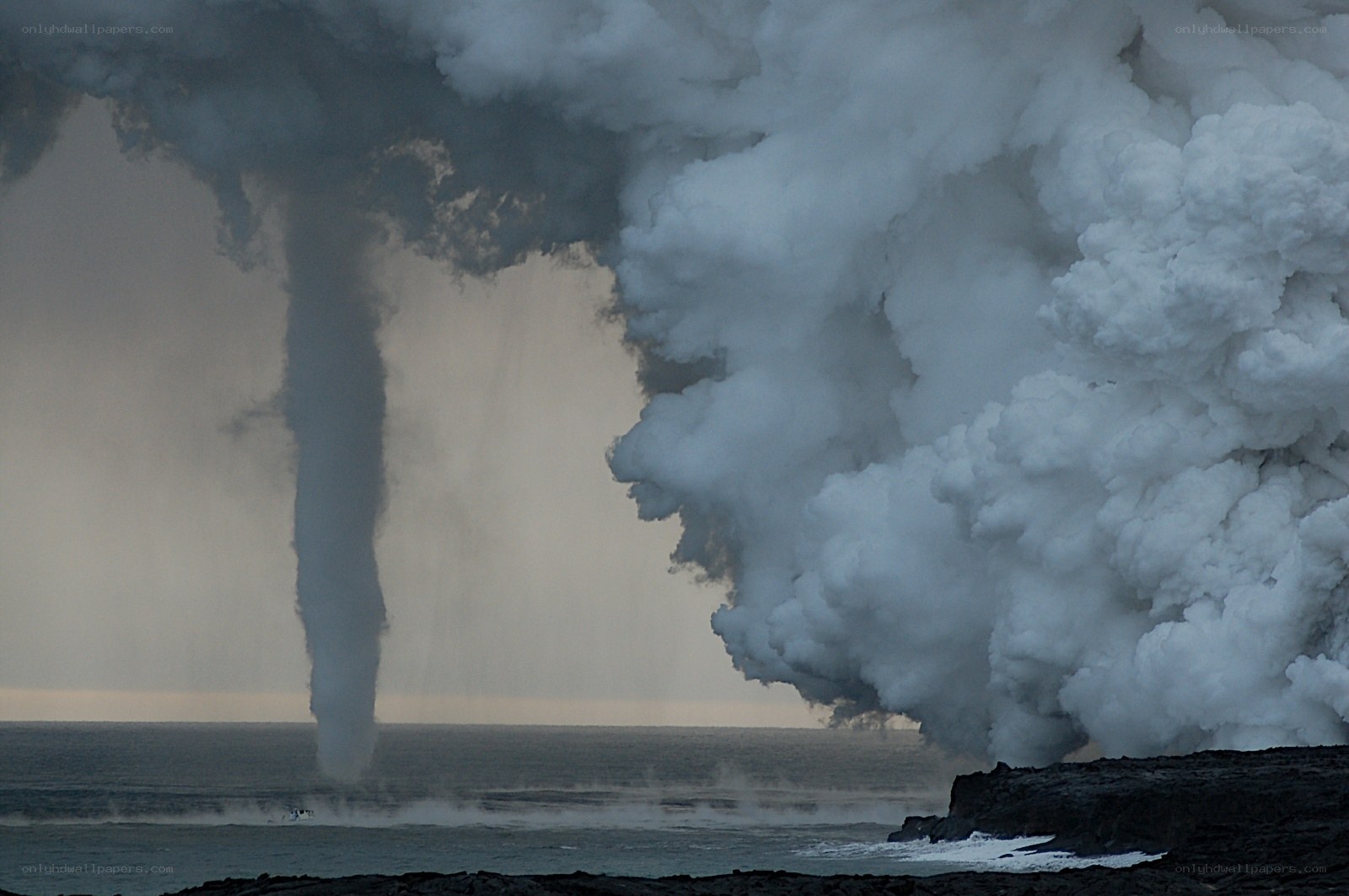 Lava meets ocean creating steam tornado
