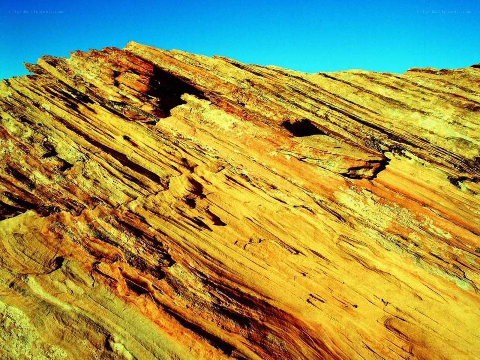 Layered rock formation under blue sky