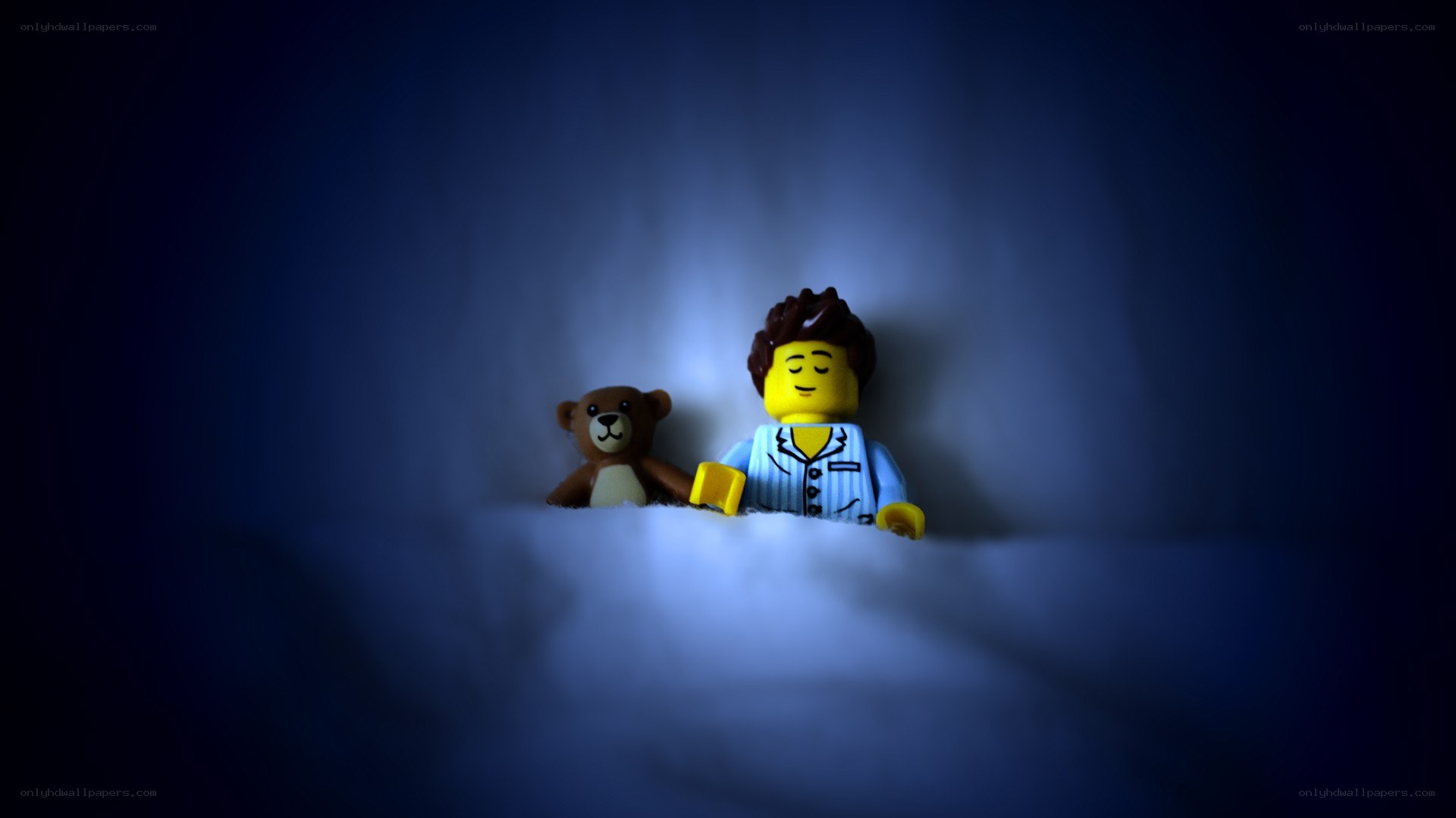 Lego figure sleeping with teddy bear