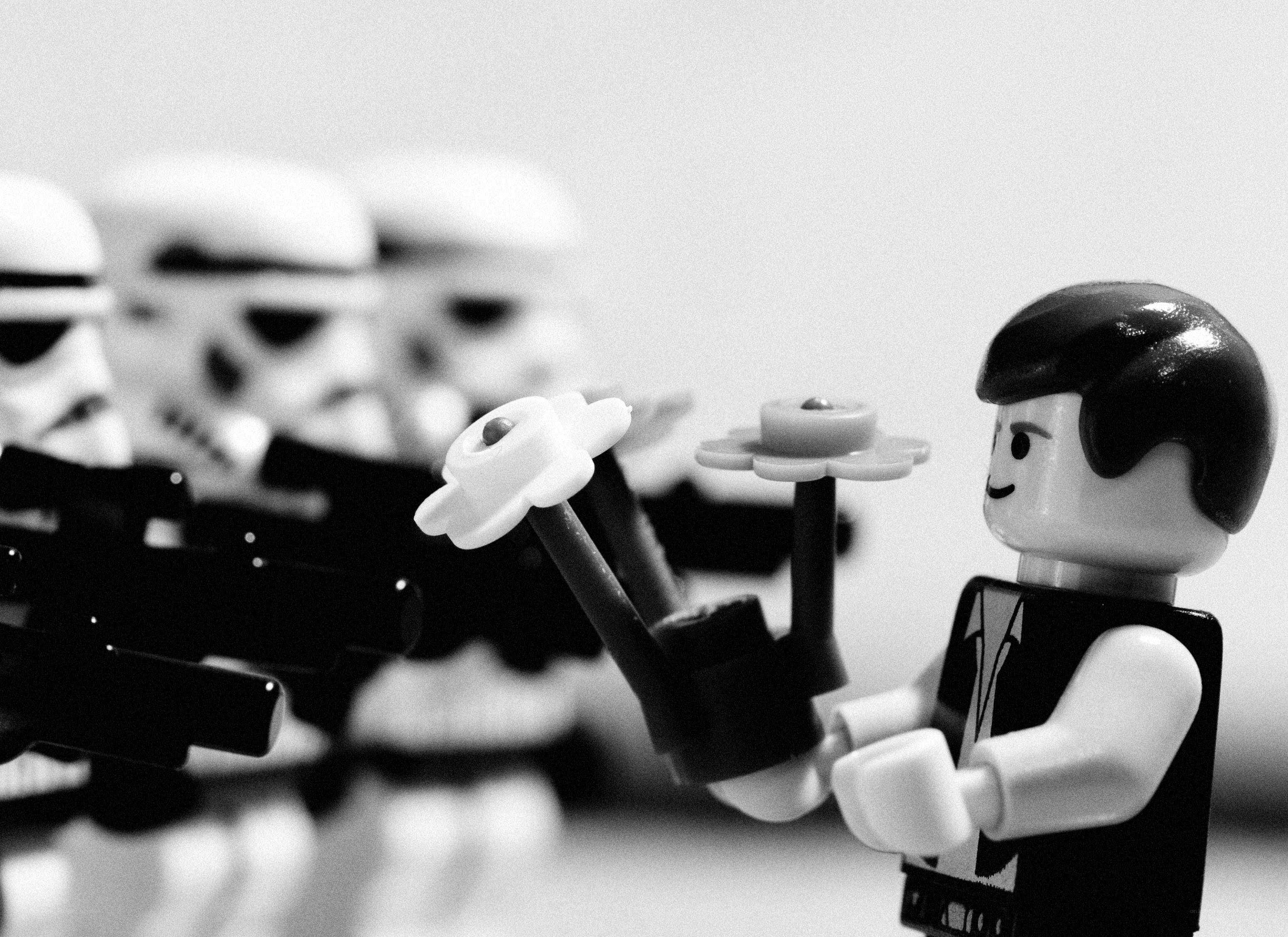 Lego figure with flowers facing stormtroopers