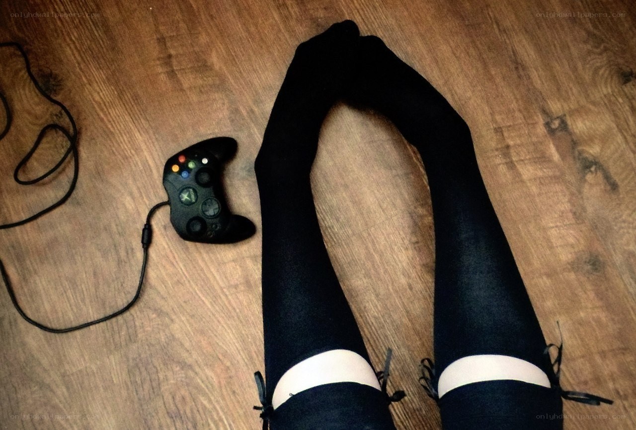 Legs in black stockings with Xbox controller