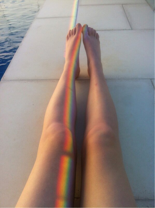 legs with rainbow light on poolside