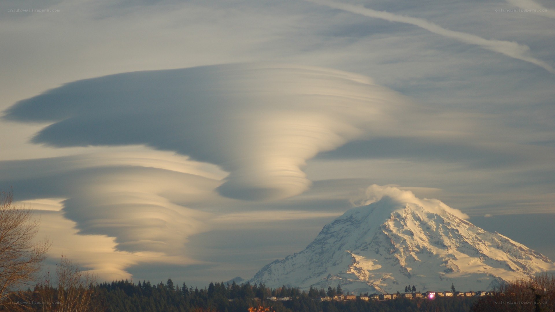Lenticular clouds over a snow-capped mountain