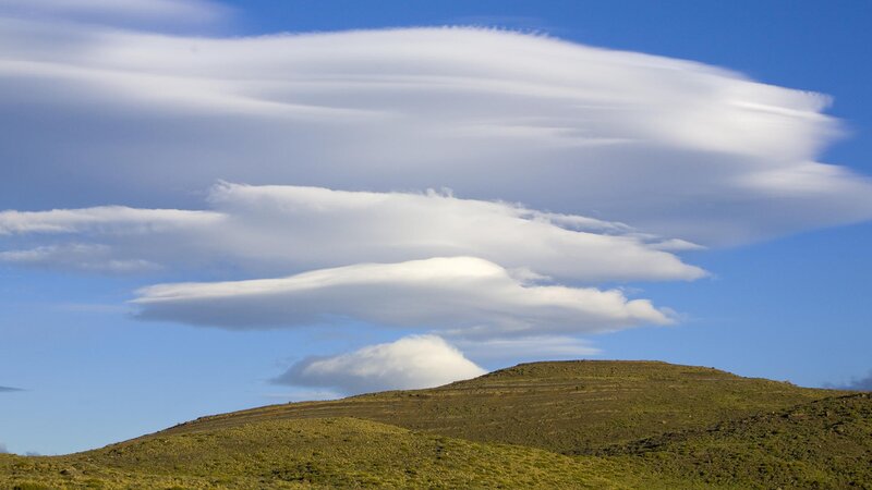 Lenticular clouds over hills