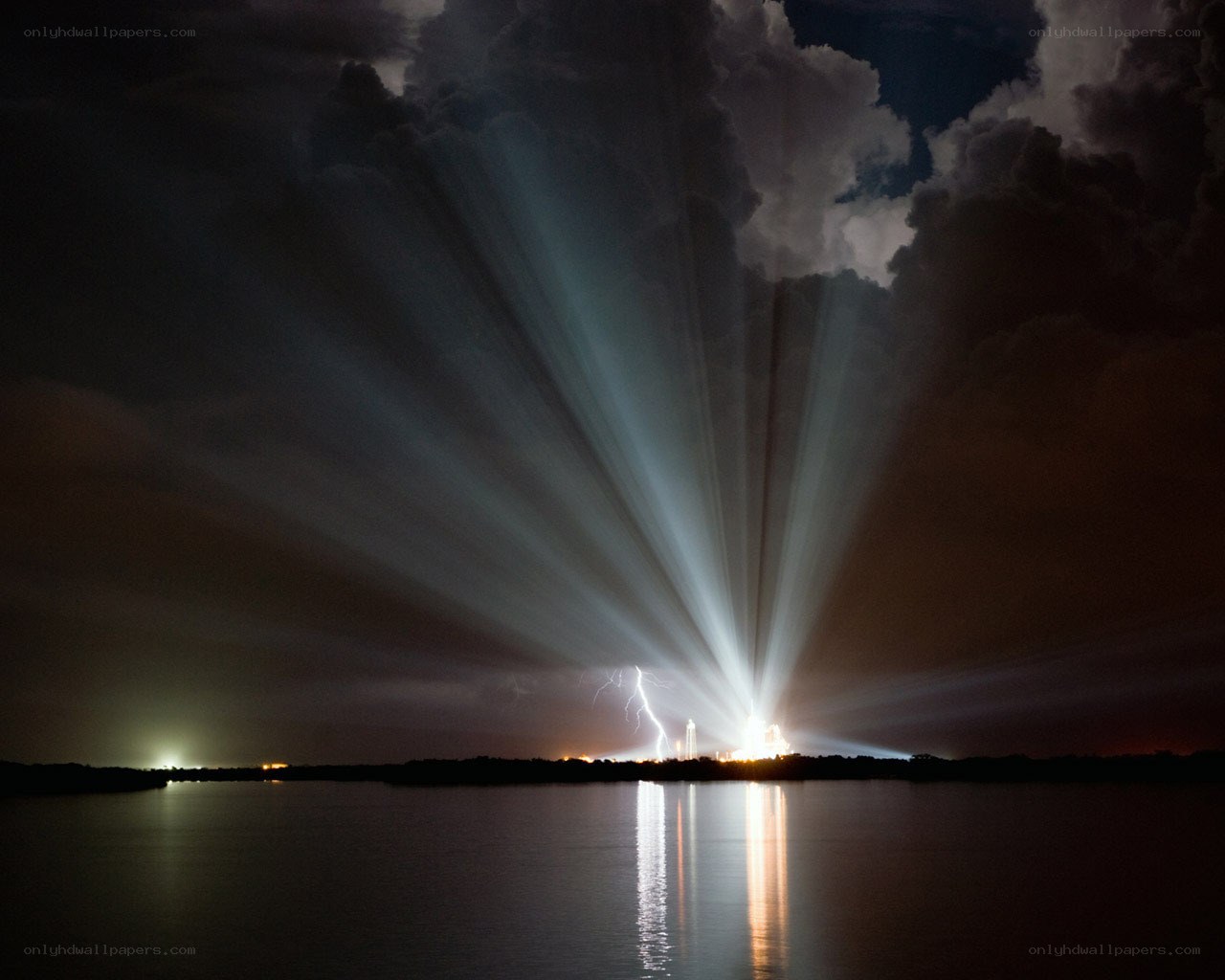 Light beams over water at night