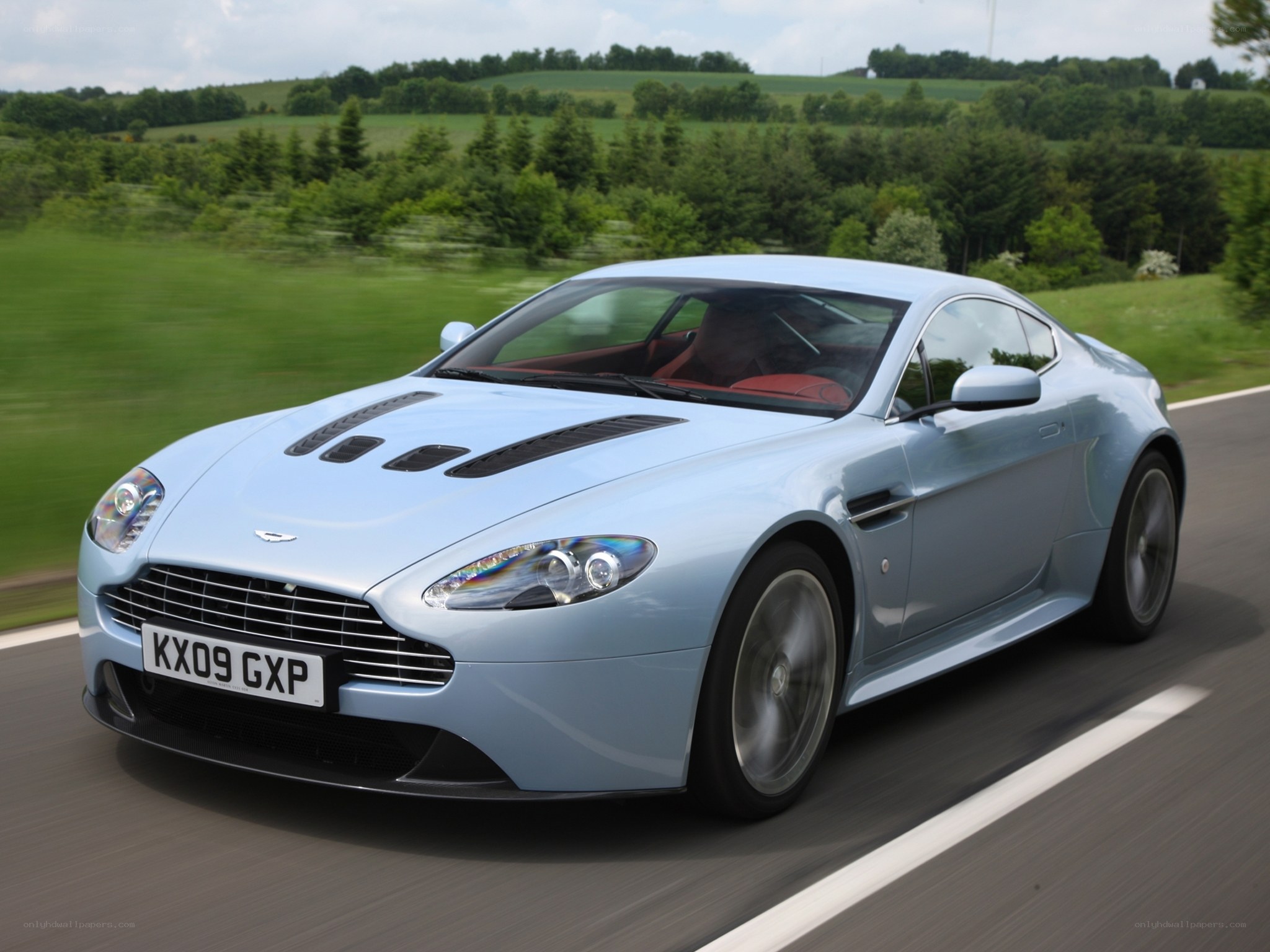 Light blue Aston Martin on country road