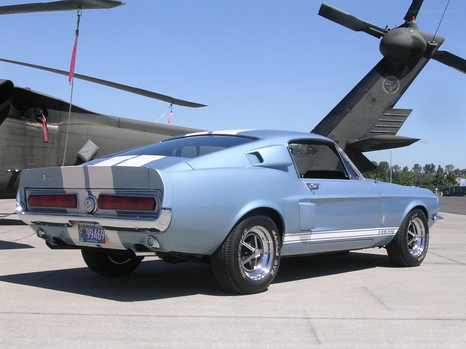 Light blue classic car with helicopter