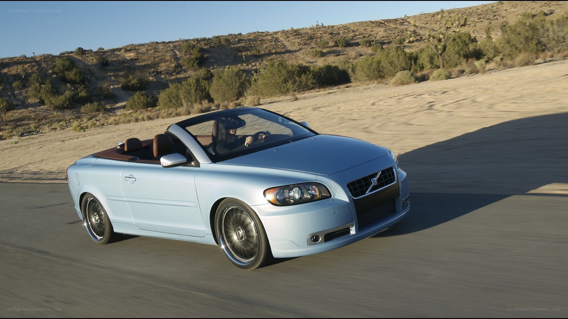 Light blue convertible driving on road