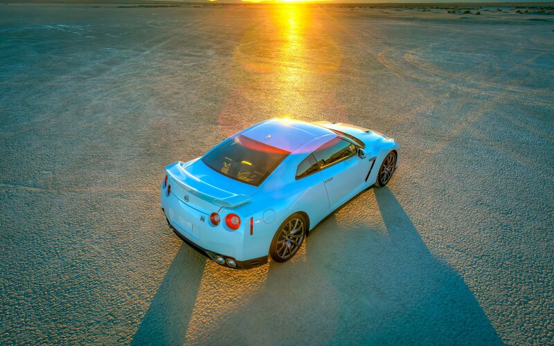 light blue sports car at sunset
