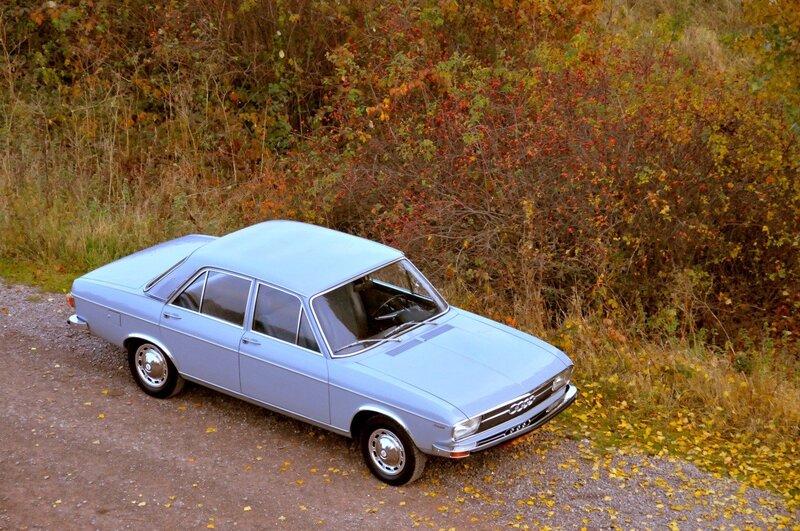 Light blue vintage Audi on a gravel path