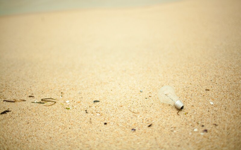 Light bulb on sandy beach