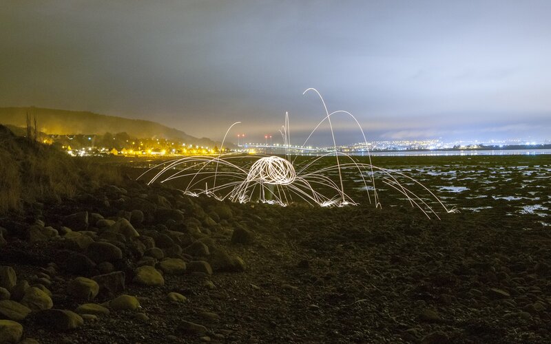 Light painting on a rocky shore