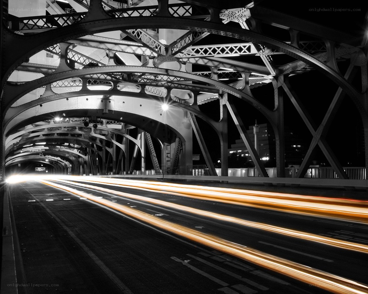 Light trails under a bridge at night