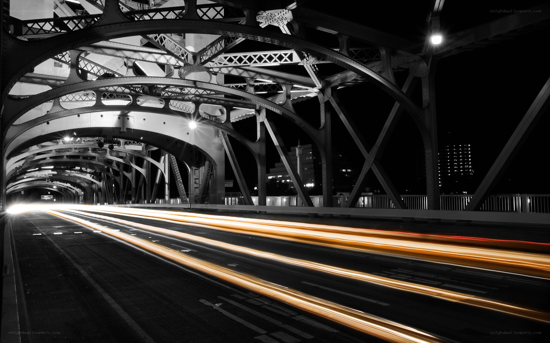 Light trails under a bridge at night
