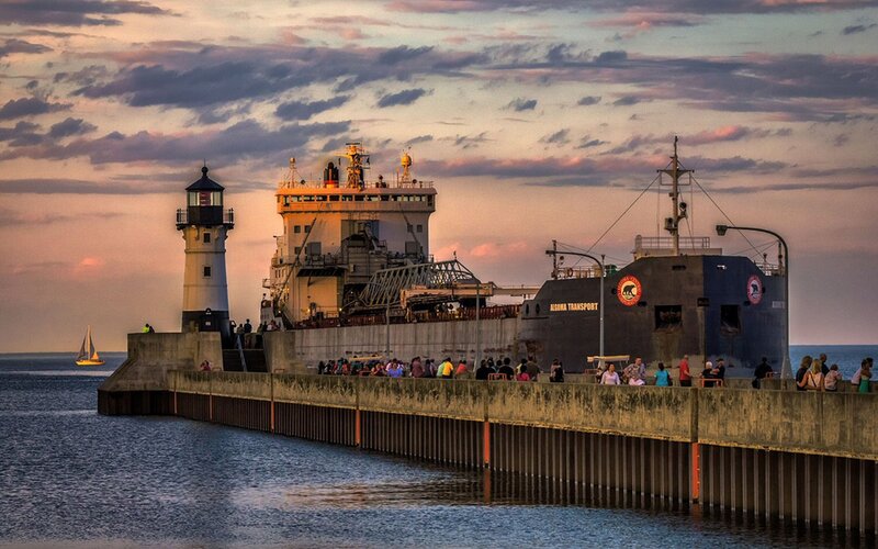 Lighthouse and ship at sunset
