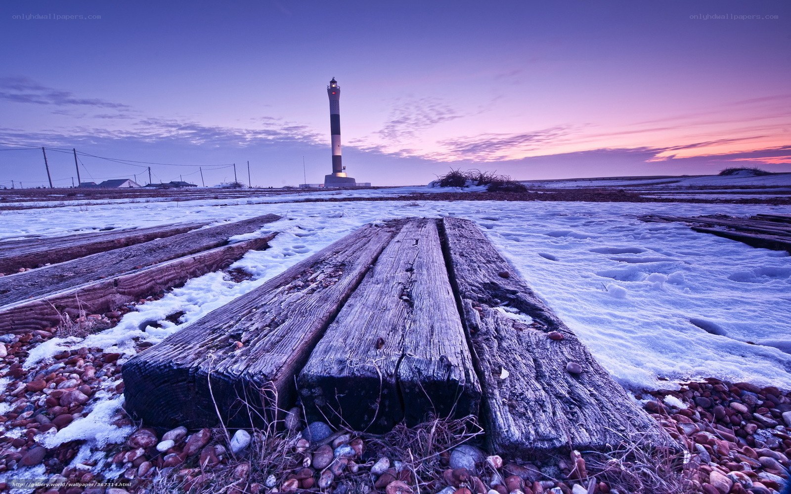 Lighthouse at dawn on snowy coast